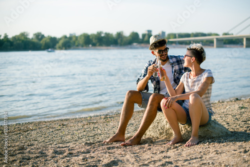 Hipsters are having drink on shore