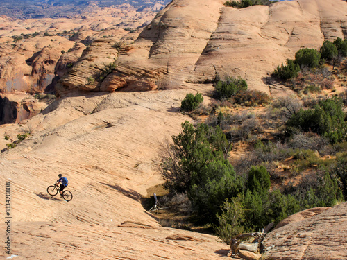 Mountain biker in a valley at Slickrock mountain biking trail in Moab, Utah photo