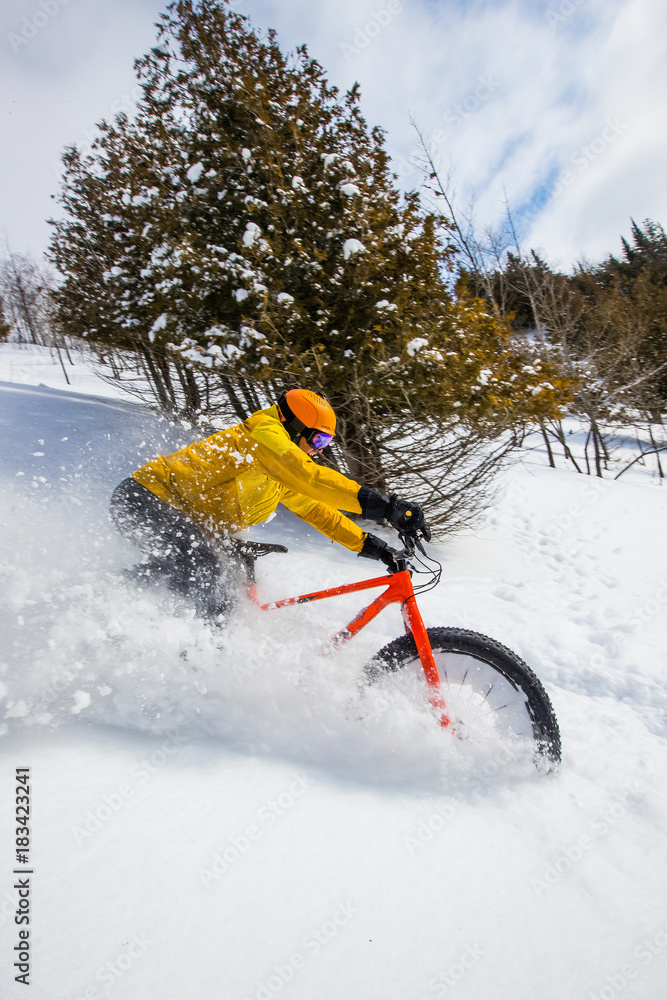 Man riding a fat bike in powder snow in the winter