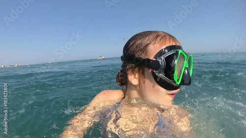 girl on pedal boat pulls off the hill into the sea, view from water photo