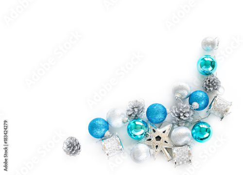 Christmas tree decorative ornaments of silver star, blue balls, pine cone and small drums over white background with copy space for Merry X'mas text insertion, logo or product decoration on new year