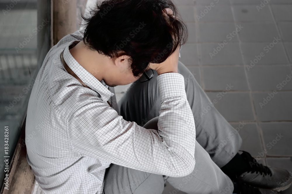 Rear view of tired frustrated stressed young Asian business man with hands on head feeling anxiety or disappointed with job. Rear view of tired frustrated stressed young Asian business man with hands on head feeling anxiety or disappointed with job.