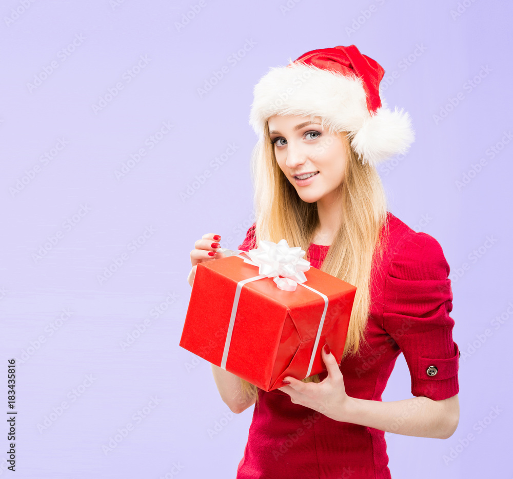Beautiful, young and pretty girl in Christmas hat over background with snow. Beautiful, young and pretty girl in Christmas hat over background with snow.