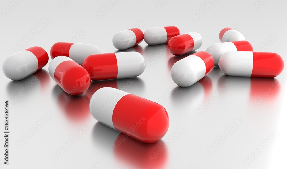 Medication capsules on metallic surface Medication capsules on metallic surface