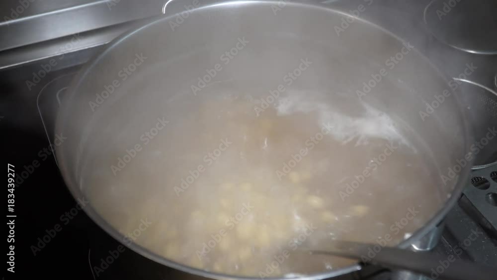 A large cooking pot with boiling soup inside A large cooking pot with boiling soup inside