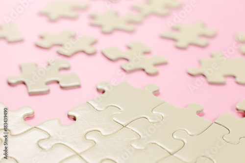 incomplete jigsaw puzzle on pink background.selective focus