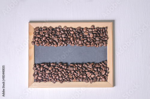Coffee beans in a wooden frame on a white background top view, free copy space