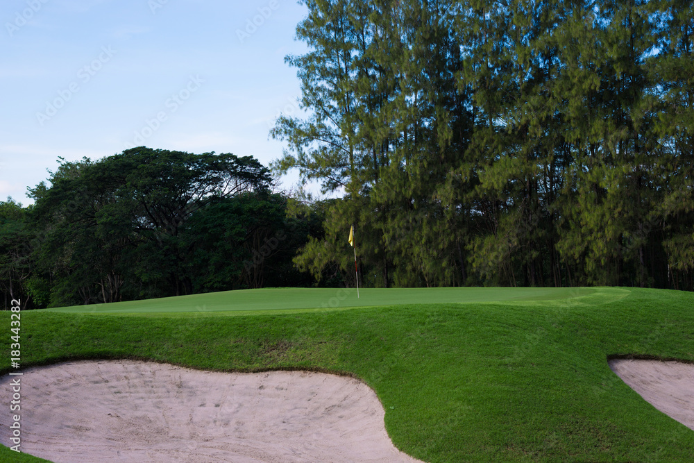 A lush green golf course under the blue sky.