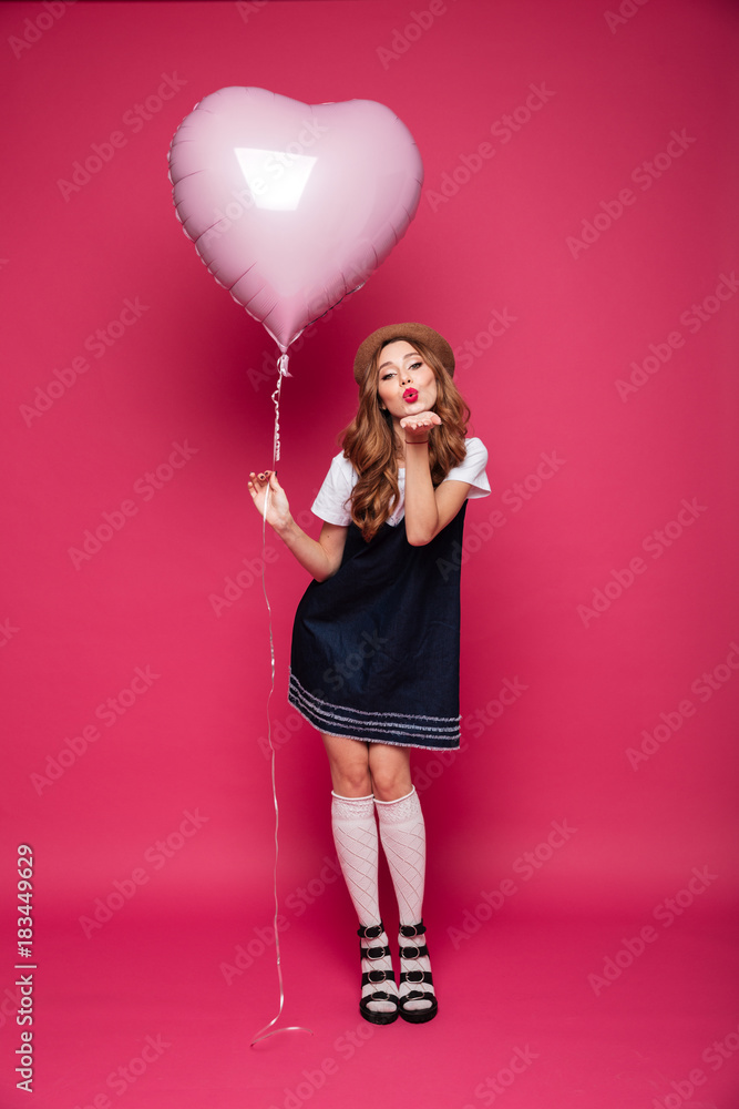 Young beautiful lady with air balloon blowing an air kiss Young beautiful lady with air balloon blowing an air kiss