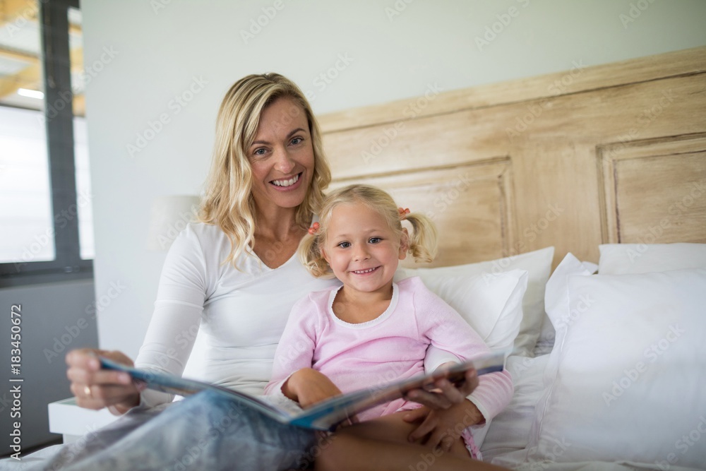 Mother and daughter reading story book in the bedroom Mother and daughter reading story book in the bedroom