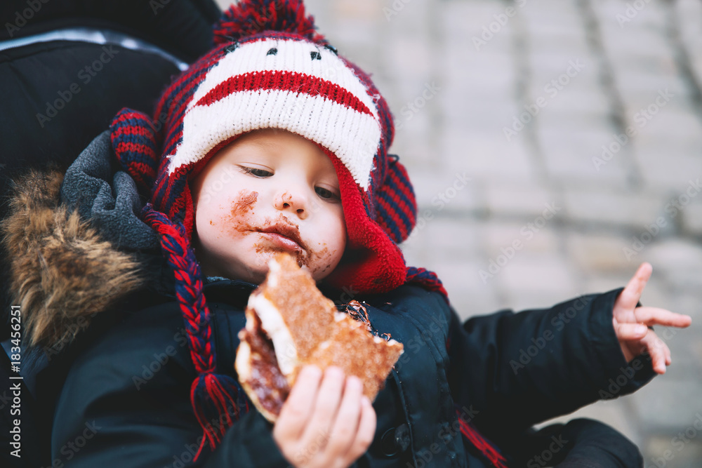 Obraz premium Child eating Trdlo or Trdelnik - Traditional National Czech Sweet Pastry Dough.