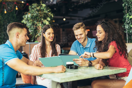 Group of young people meeting in a cafe  having fun.