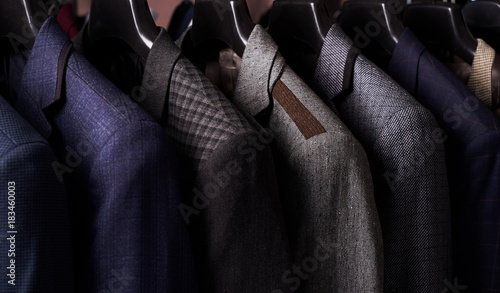 Mens suits on hangers in different colors photo