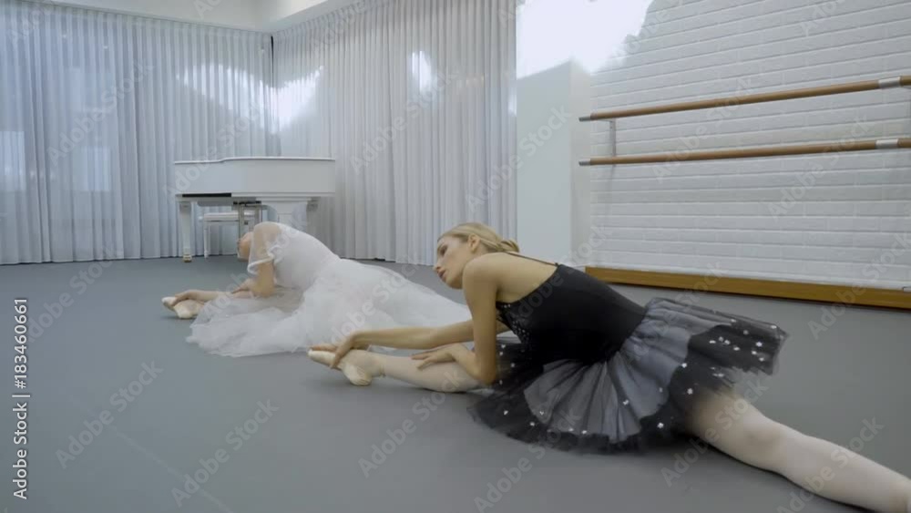 The ballerinas does the middle split and inclines to the right leg in ...