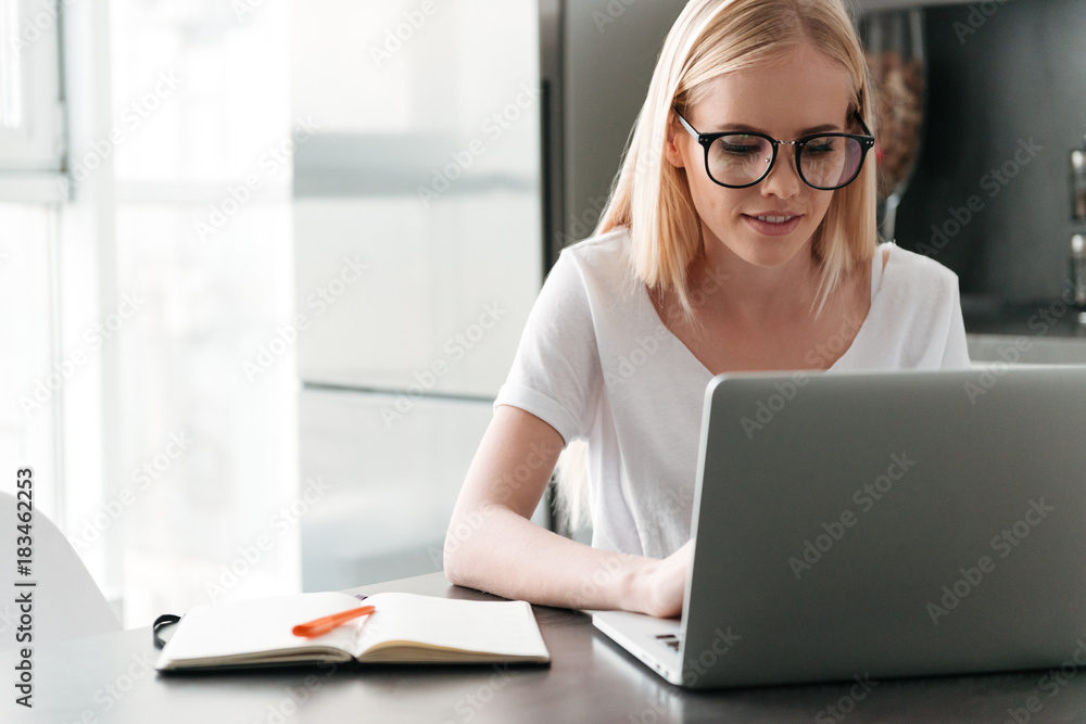 Concentrated young lady working with laptop at home Concentrated young lady working with laptop at home