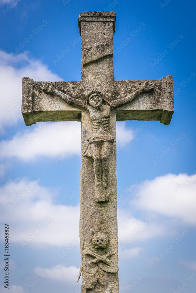 Stone cross on abandoned Catholic cemetery near Chervonohorod Castle ruins in Ukraine