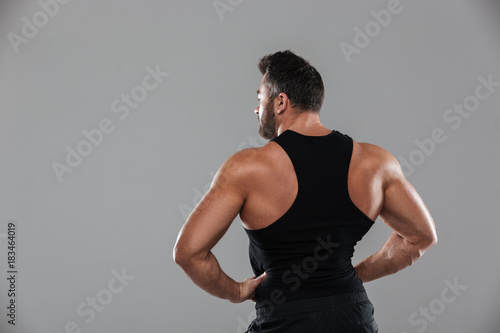 Back view of a muscular strong male bodybuilder