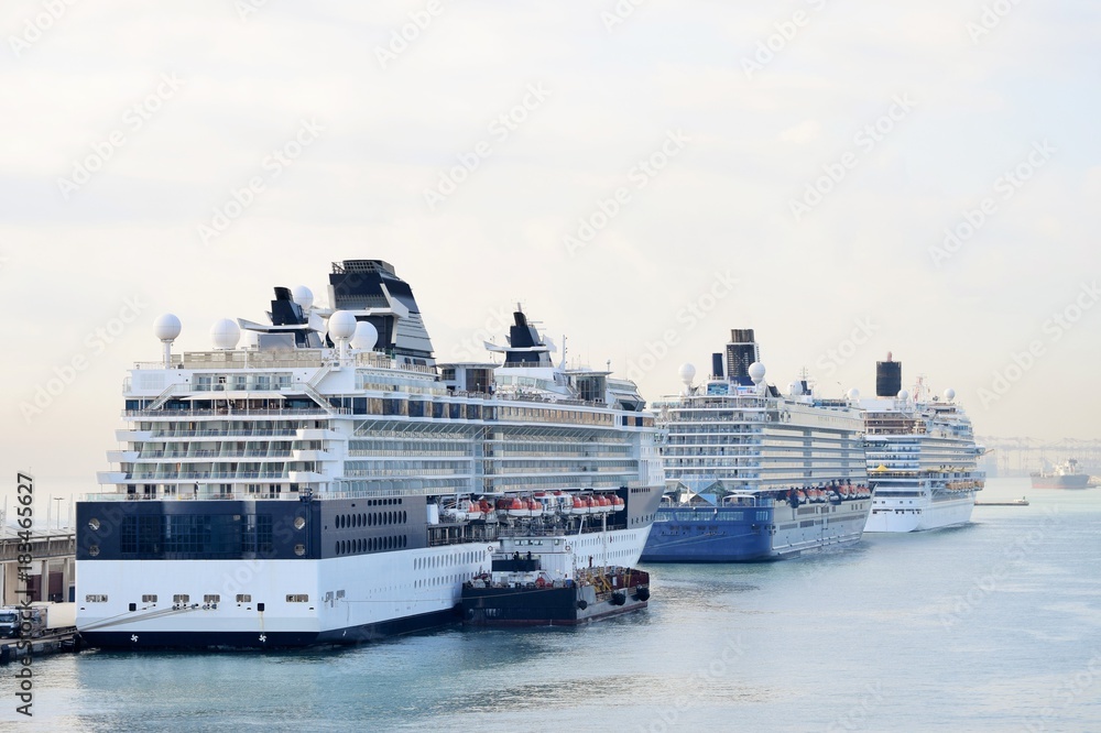 Drei große Kreuzfahrtschiffe (Steuerbord) im Hafen vor Anker - ein Kreuzfahrtschiff wird gerade betankt