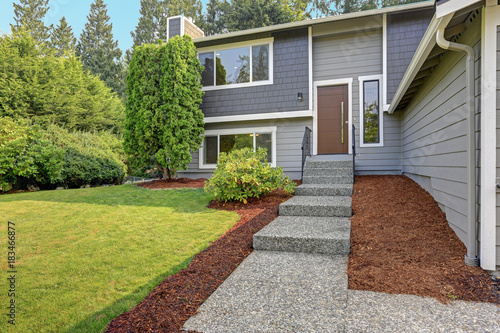 Foto Concrete pebble stone pathway leads to a grey home