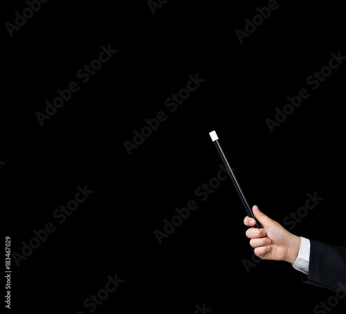 Magic wand in child hand - on black background