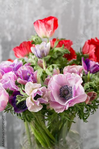bouquet of mixed anemones flowers in vase . the work of the florist at a flower shop.