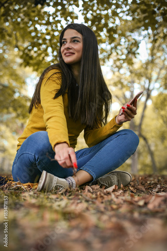 Young woman at park using smart phone.