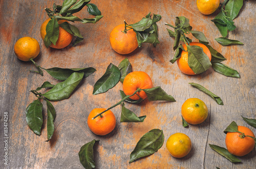 set of fresh tangerines with leaves on an old wooden background