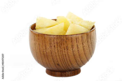 slices of pineapple in wooden cup isolated