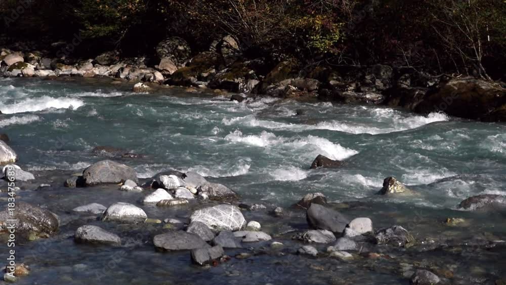 Autumn river, Slow motion view of a turqouise mountain river, on a sunny fall day, near grindelwald, in bern, switzerland Autumn river, Slow motion view of a turqouise mountain river, on a sunny fall day, near grindelwald, in bern, switzerland