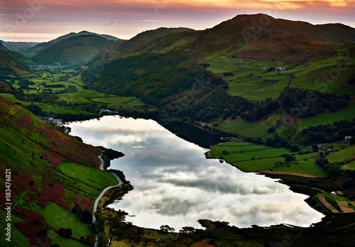 Sunset at Tal-y-llyn Lake south of Cadair Idris massif looking down the Dysynni Valley with the peak of Foel Ddu on the right. In the distance are the village of Abergynolwyn and the Irish Sea. photo