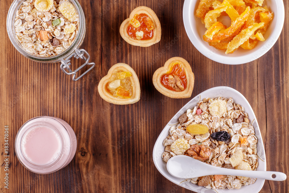 Healthy breakfast. Ceramic bowl with oat flakes, dried fruits, nuts on wood background Healthy breakfast. Ceramic bowl with oat flakes, dried fruits, nuts on wood background