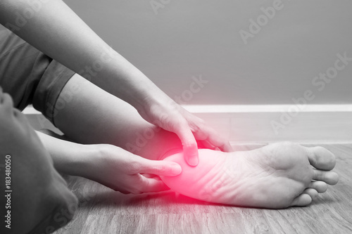 Valokuva Female foot heel pain with red spot, plantar fasciitis