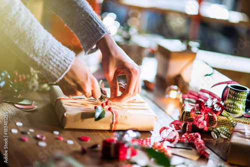 Christmas time. close-up on woman's hands wrapping a gift