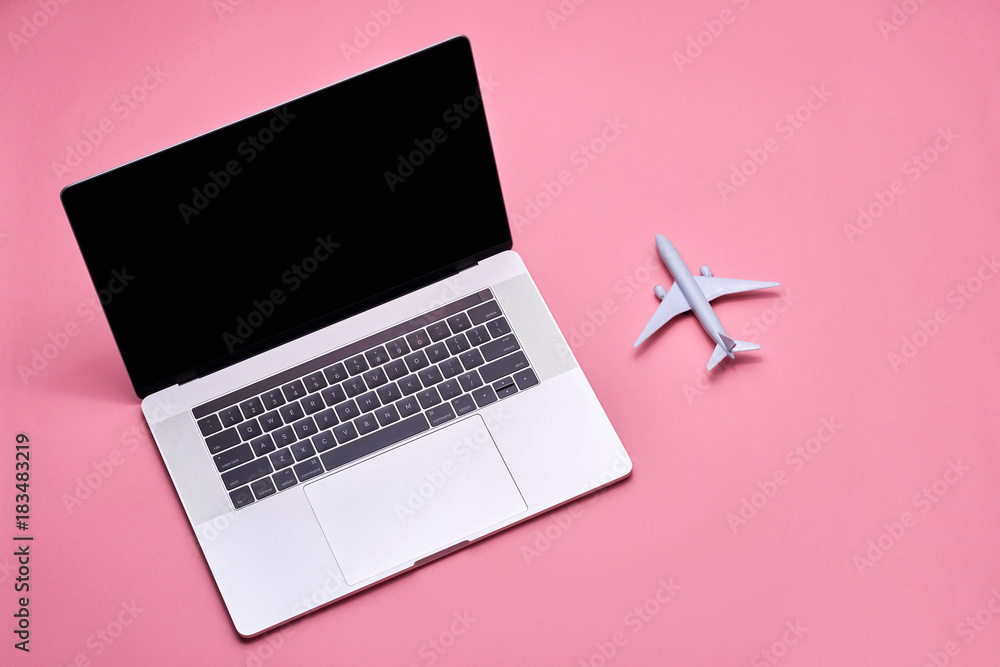 Travel and planing concept. Airplane toy model with laptop computer Travel and planing concept. Airplane toy model with laptop computer