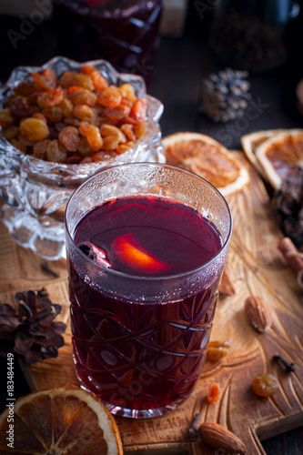 Scandinavian hot alcoholic drink with cinnamon in a glass cup on a wooden board, selective focus photo