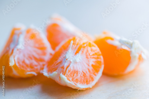Closeup pieces of peeled tangerine on wooden board
