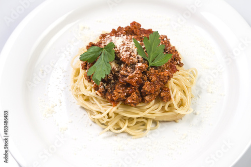 Italian spaghetti pasta with beef and tomato sauce bolognese on white plate