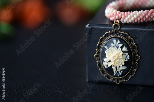 Short beaded choker with rose cameo on a dark background close up