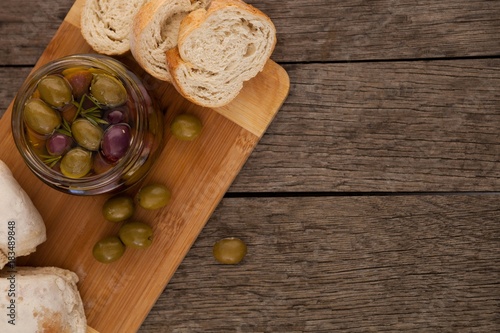 Close up of olives in container by bread