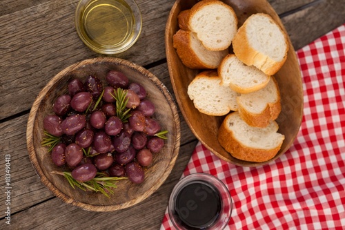 Overhead view of olives and bread in plate on table