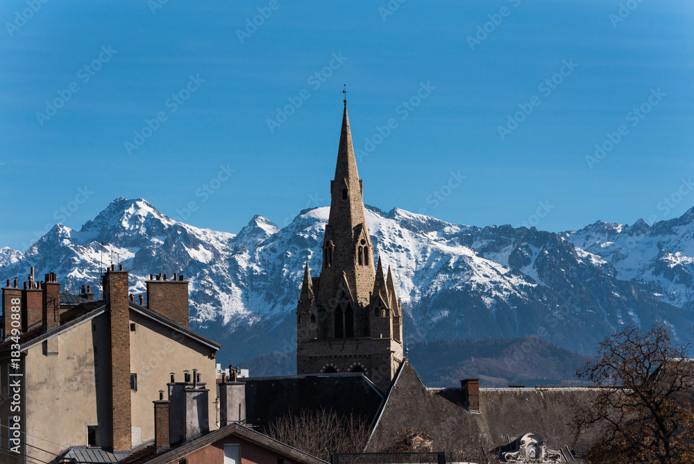medium shot of The Collegiate Church of Saint-André, Grenoble and the Belledonne mountain range in the background