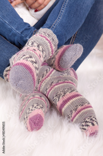 Legs of woman in knitted woolen pink socks. Closeup