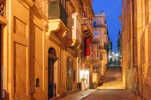 Typical Maltese medieval street at night in the center of the Old Town of Valletta, Malta © Kavalenkava