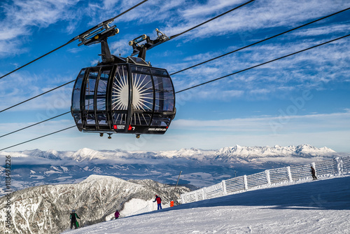 Skiers on the slope. Cableway Funitel in Low Tatras mountains, Slovakia.