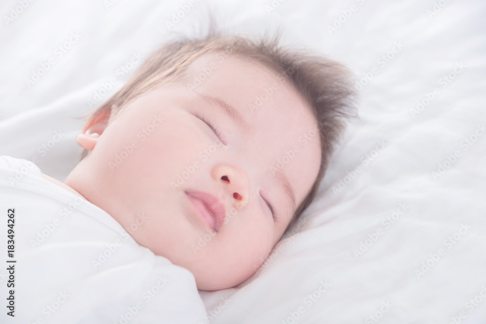 Closeup little asian baby girl wearing white cloth sleeping on white bed Closeup little asian baby girl wearing white cloth sleeping on white bed