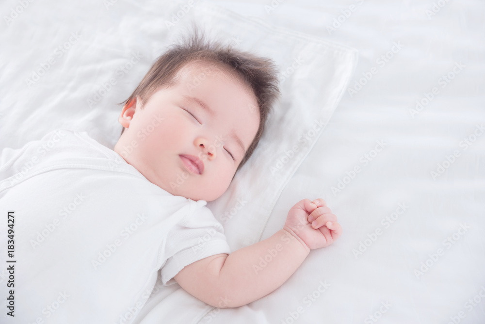 Little asian baby girl wearing white cloth sleeping on white bed Little asian baby girl wearing white cloth sleeping on white bed
