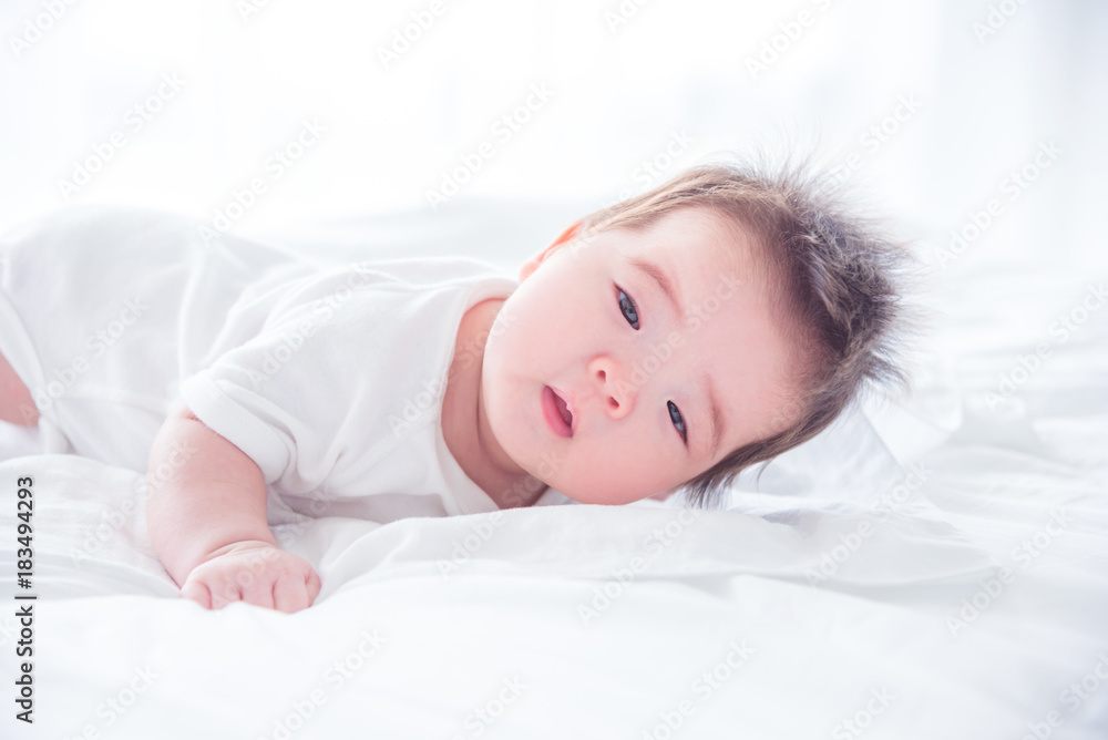 Little asian baby girl waking up on bed in the morning Little asian baby girl waking up on bed in the morning