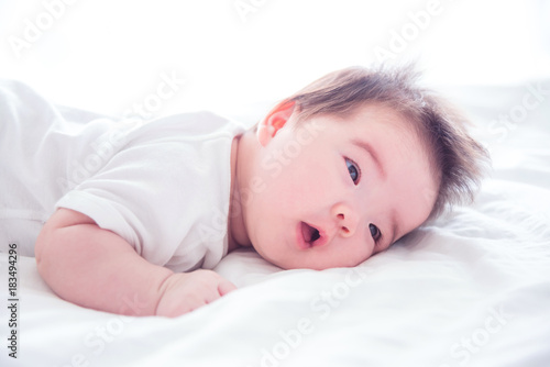 Little asian baby girl waking up on bed in the morning