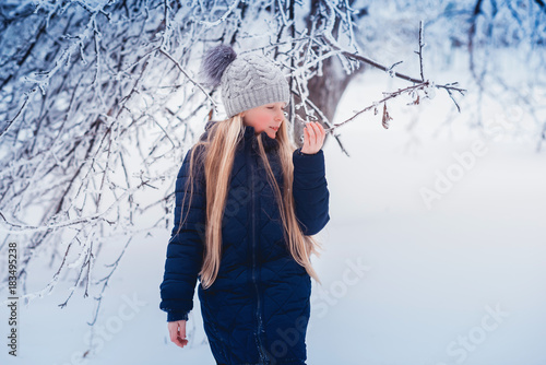 Winter girl blowing snow. Beauty Joyful Teenage Model Girl having fun in winter park. Beautiful girl laughing outdoors. Enjoying nature. photo