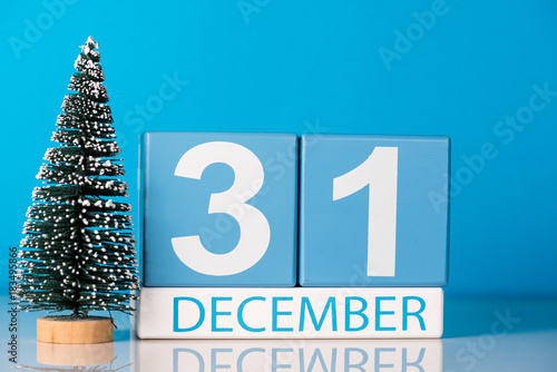 New year. December 31st. Day 31 of december month, calendar with little christmas tree on blue background. Winter time. New year concept photo